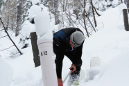 Mann schaufelt eine Röhre frei von Schnee.