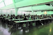 Blick in das Plenum, alle Sitzen in Reihen an Tischen