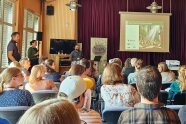 Ein Saal mit vielen Besuchern, die einem Vortrag der LWF lauschen.