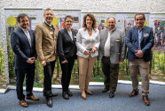 6 Personen auf einem Gruppenbild vor Aufstellern.