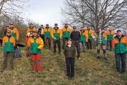 Gruppenbild von Förster/innen in Arbeitskleidung an einem Hang