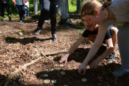 Kinder haben Holzscheiben in der Hand und spielen mit ihnen auf dem Waldboden