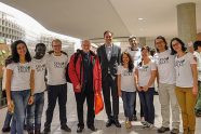 Eine Gruppe Menschen, bestehend aus Studenten und Studentinnen, welche alle weiße Tshirts mit dem Aufdruck SRM Talks tragen, rahmen zwei Männer ein.