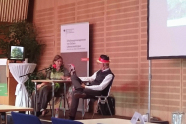 Eine Frau und ein Mann sitzen auf einer Bühne und diskutieren