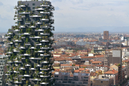 Modernes Hochhaus mit Bäumen auf Balkons in großer Stadt