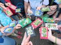 Kinderhände halten selbstgebastelte Bilder mit Pflanzenteilen.