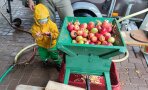 Kleinkind an einer Schubkarre voller Äpfel