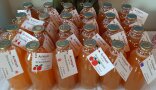 Kleine Apfelsaftflaschen mit um Flaschenhals gebundenen Etiketten.