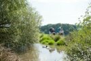 Pflegefachkräfte und Senioren halten sich am Ufer eines Weihers auf