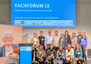 Gruppenbild mit 14 Frauen und Männer vor dem Plakat Fachforum 13, Soziale Landwirtschaft: Eine Chance auf dem Land