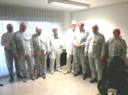 Personen in Schutzanzügen in einem Raum