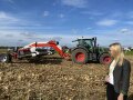 LfL-Mitarbeiterin im Feld vor landwirtschaftlicher Maschine
