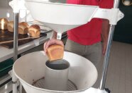 Brot wird in ein Messbehälter zur Bestimmung des Brotvolumens eingelegt