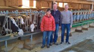 3 Personen der Familie Breinbauer im Stall vor ihren Kühen