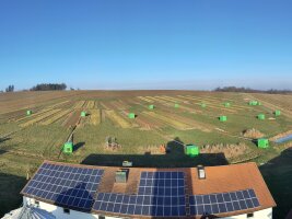 Luftbilld eines landwirtschaftlichen Gebäudes an einem Feld mit Messvorrichtungen.