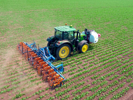 Ein Traktor im Feld von oben zu sehen.