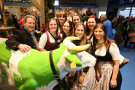 Herr Steinberger hinter der LfL-Kuh mit einer Gruppe junger Frauen im Dirndl.