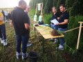 Zwei Menschen vor einem Tisch im Feld.