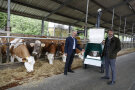 Zwei Personen begutachten eine GreenFeedStation in einem Milchviehstall
