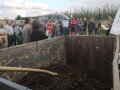 Container mit Kompost im Vordergrund und den Besuchern im Hintergrund. 