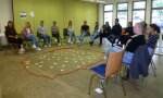 Gruppe von Auszubildenden, die in einem Tagungsraum im Kreis sitzen. 