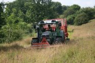 Traktor beim Mähen einer Wiese.