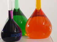 drei Reagenzgläser mit jeweils lila, grünem, orangen flüssigen Inhalt